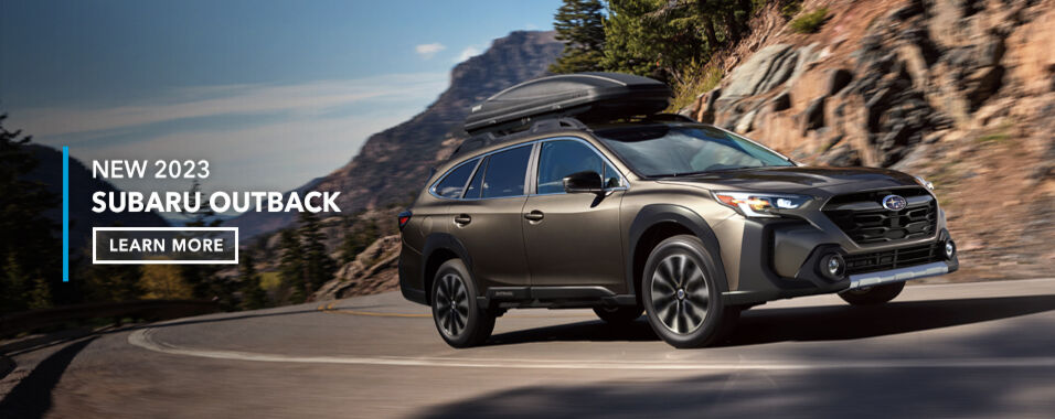 Brilliant Bronze 2023 Subaru Outback rounding the bend on a curved road.